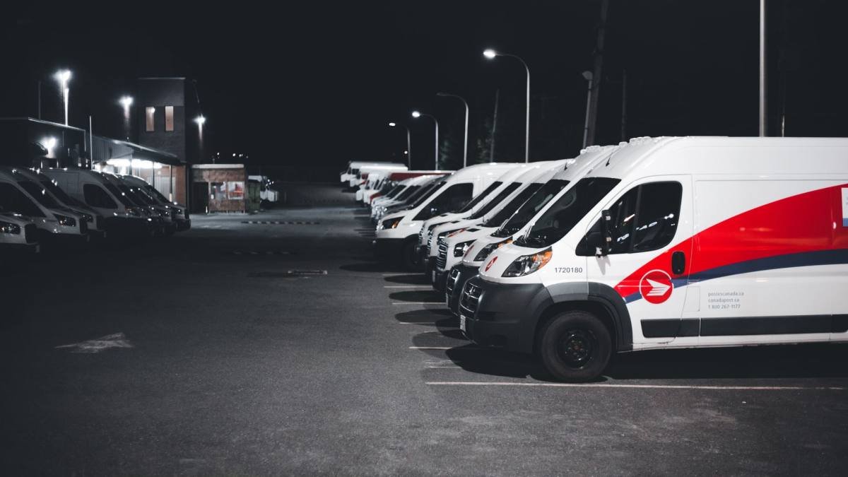 A row of white vans parked side by side