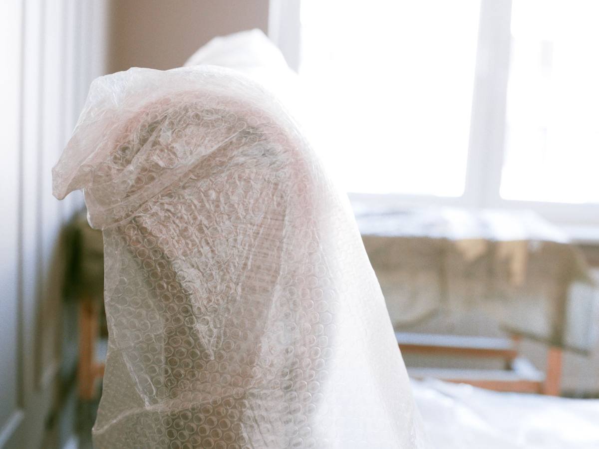 A piece of furniture wrapped in a protective blanket