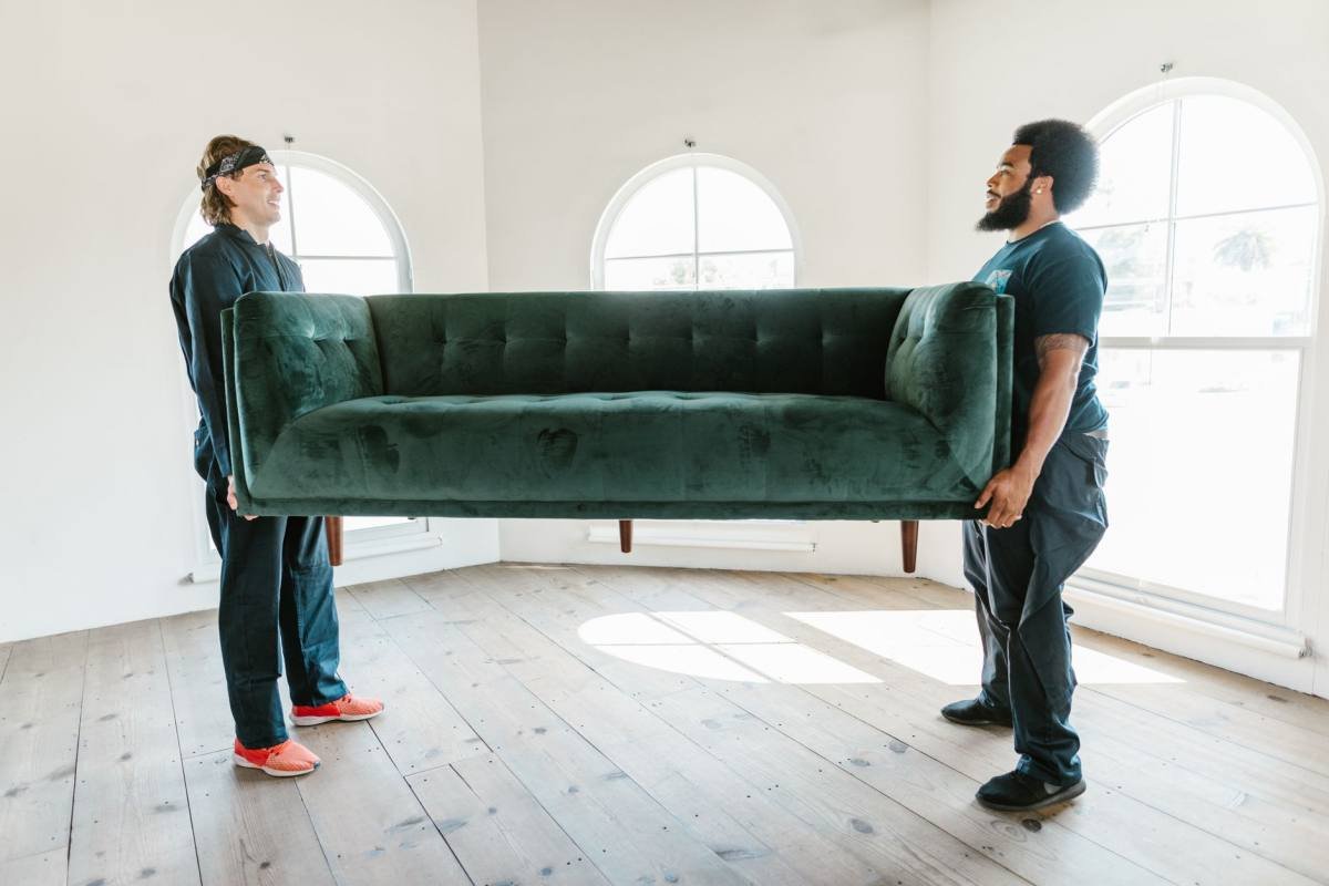 Two men carrying a sofa together