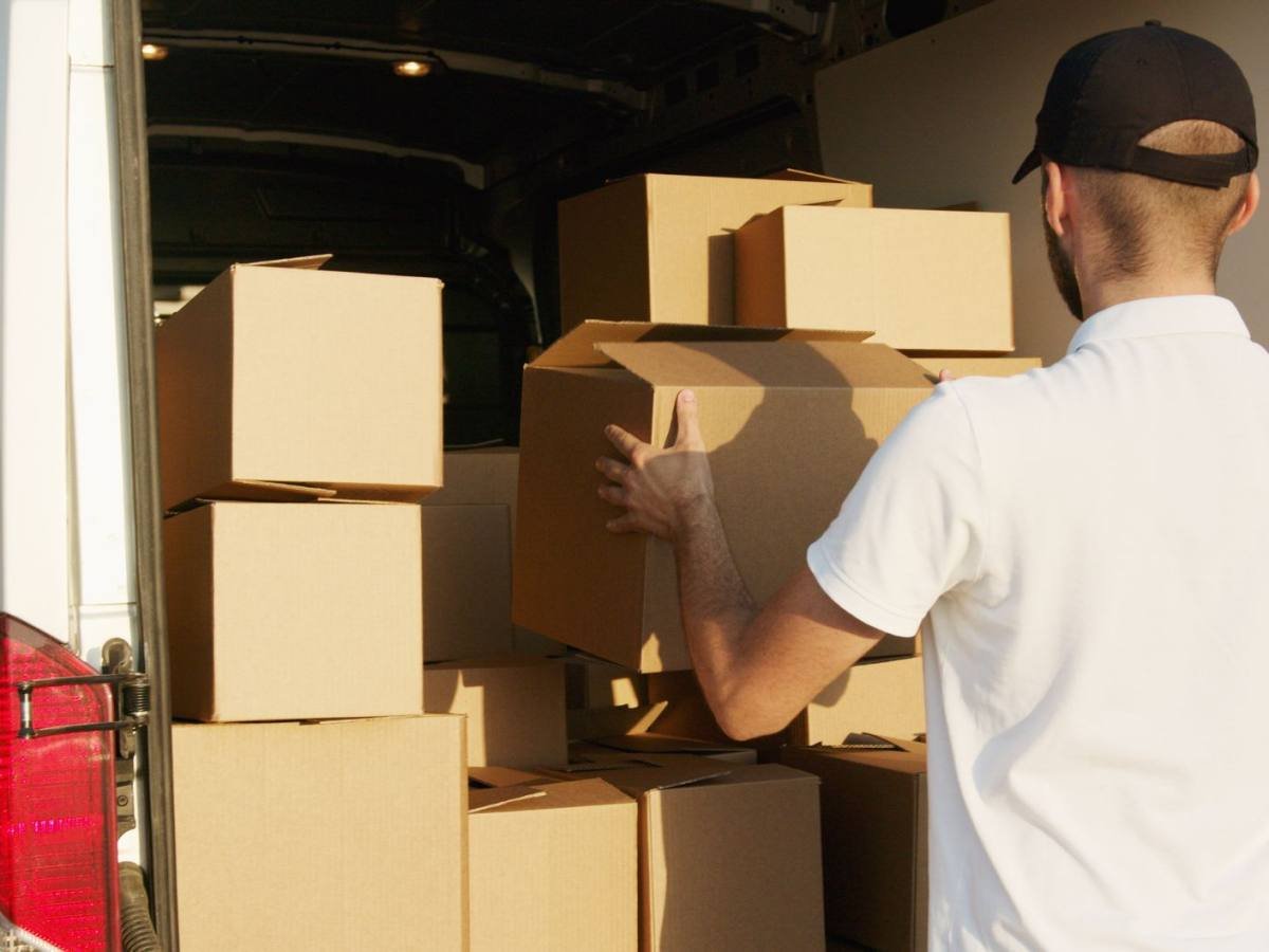 Two movers loading furniture into the back of a van
